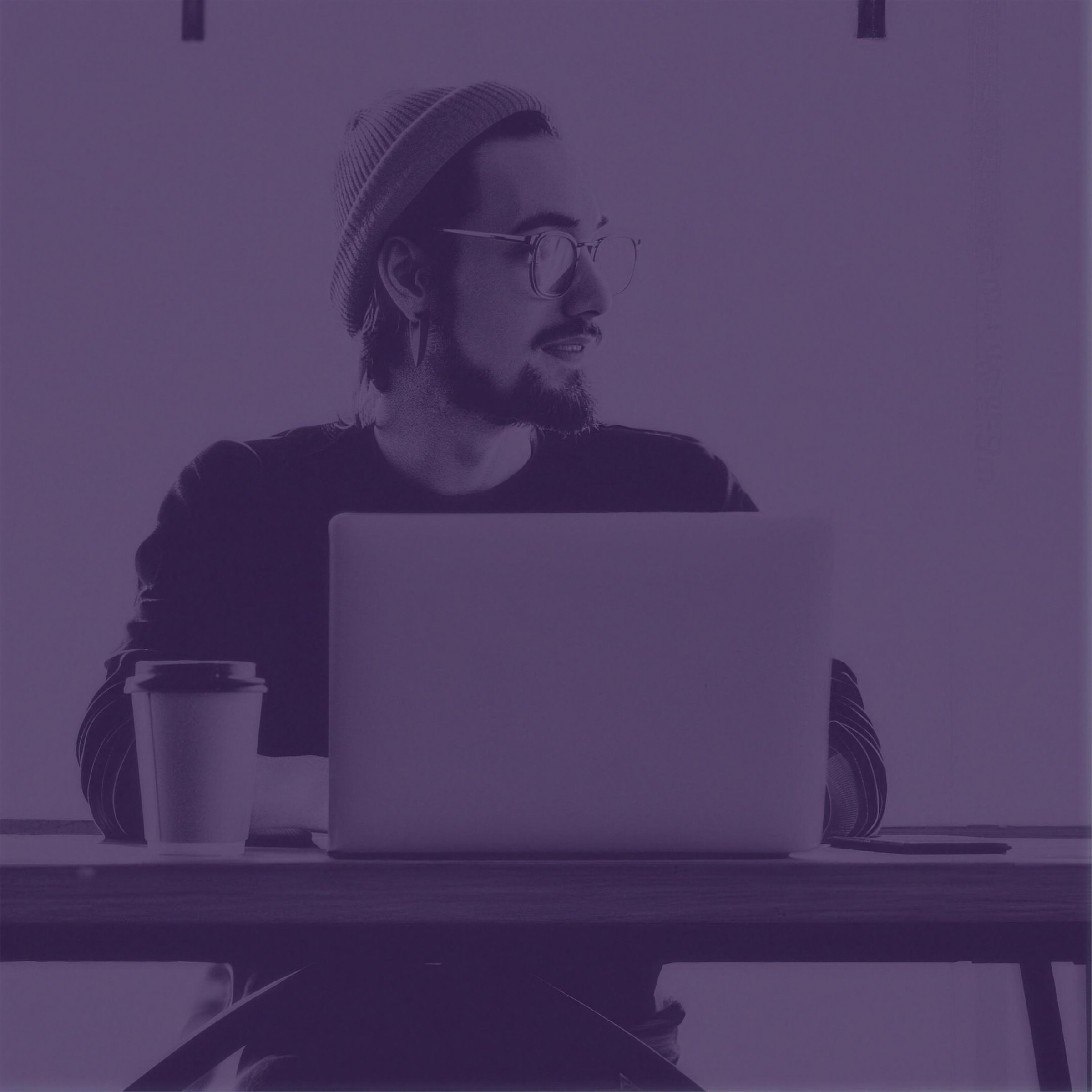 Man at a laptop in a purple FEEDERS duotone photo
