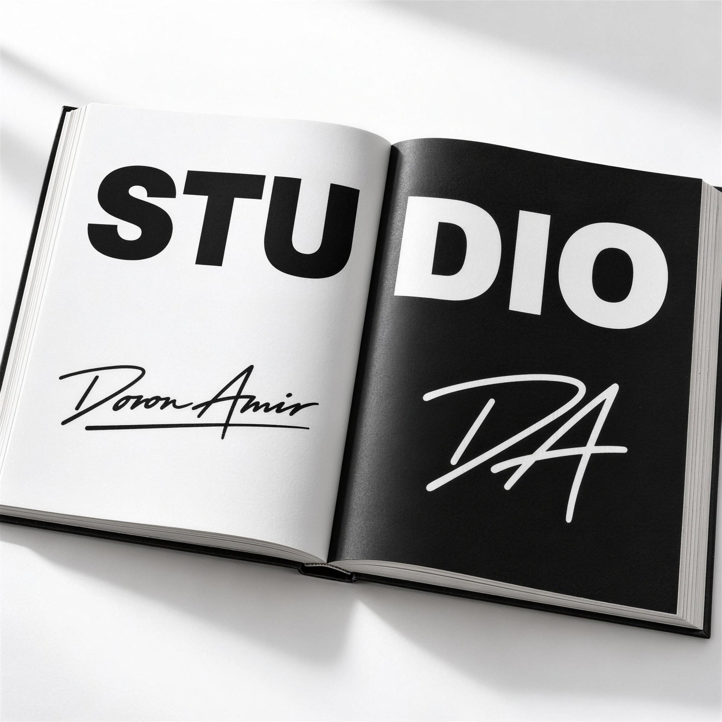 Open book with STUDIO across both pages, the signature on white and the DA monogram on black