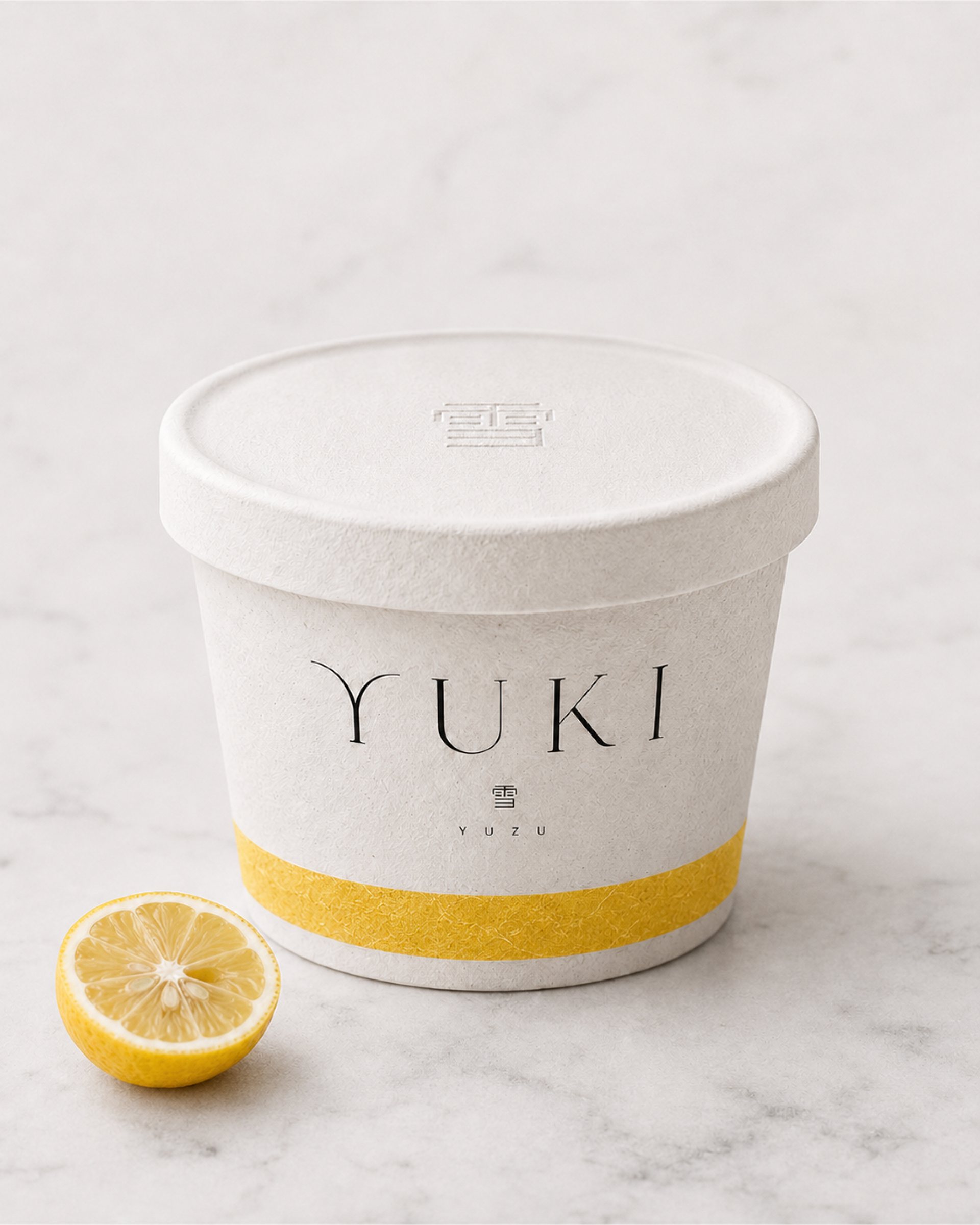 YUKI ice cream tub with a yellow band beside half a lemon